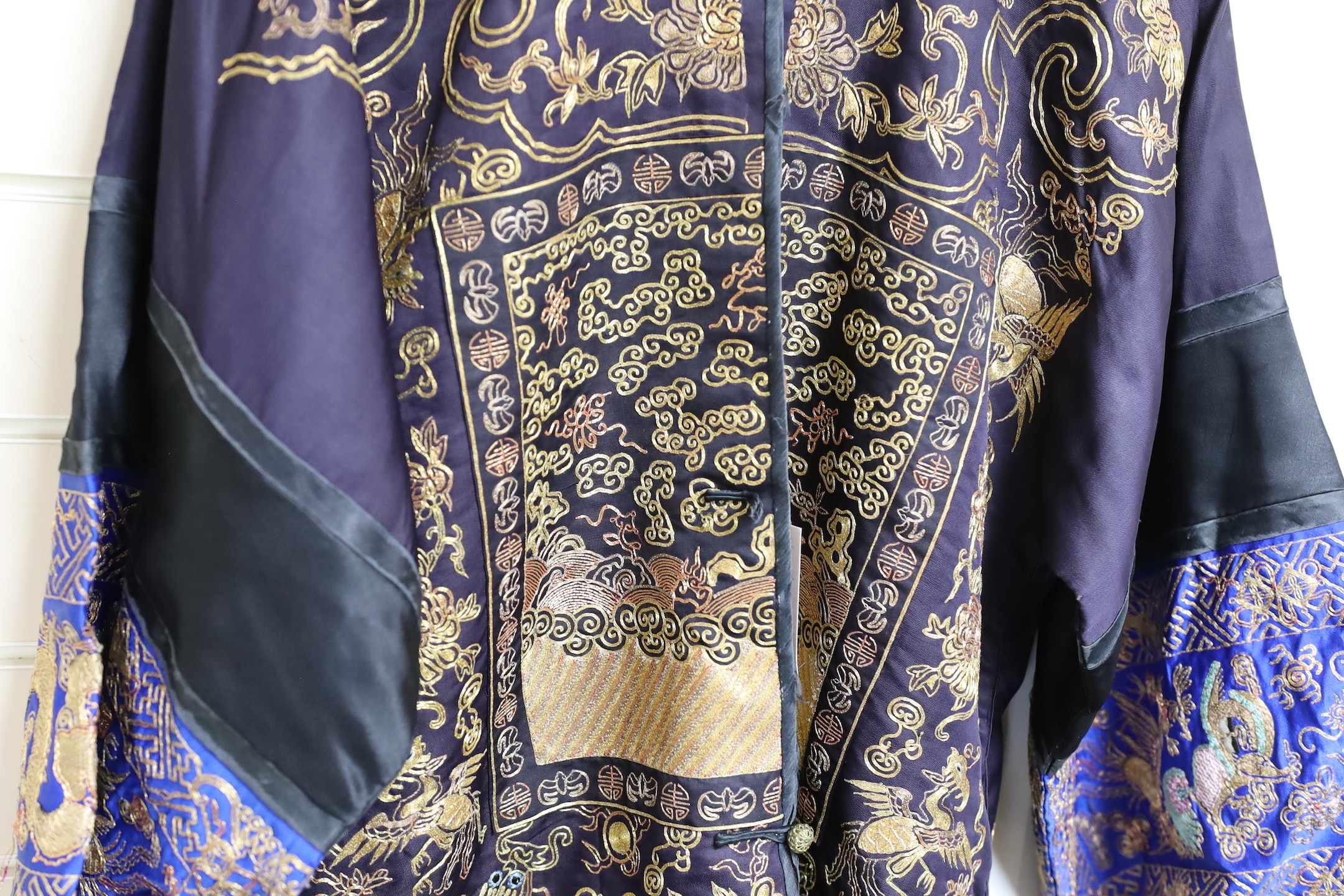 A 20th century Chinese robe, decorated with navy ground and gilt thread all over five claw dragons
